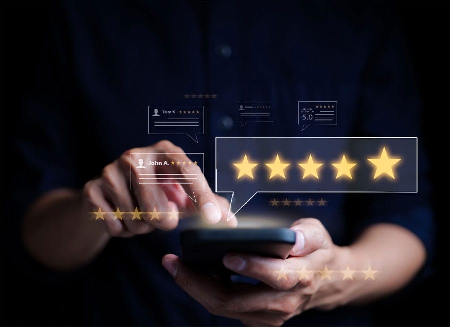 Person tapping cell phone screen with 5 star ratings boxes overlaid